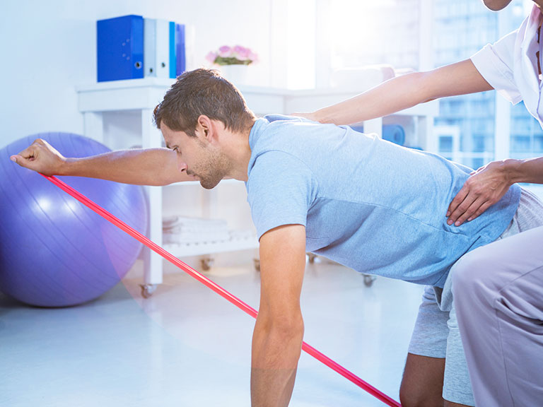 Patient suffering from back pain receiving Therapeutic Exercise